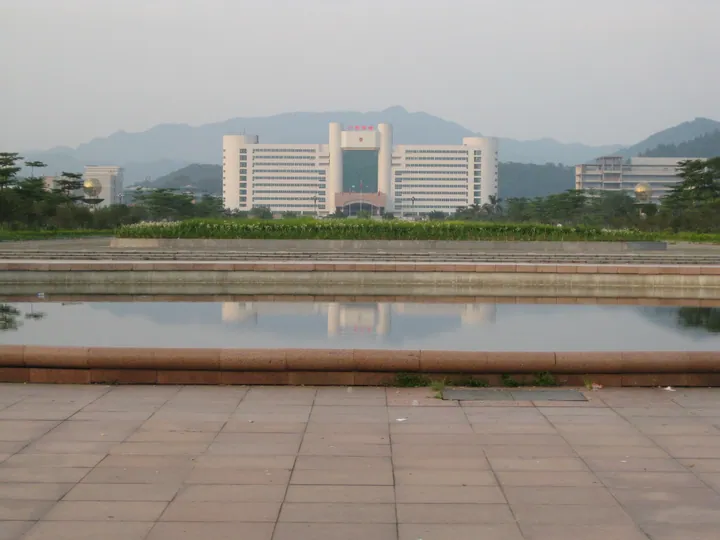 Government office building reflected in a plaza pool with mountains in the background