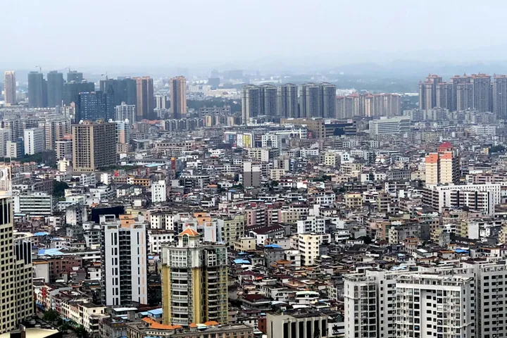 A wide view of a dense town skyline seen from a hillside