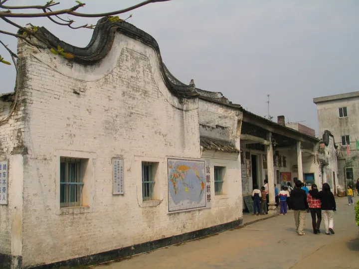 Old whitewashed academy building with a world map mural in Yangxi County