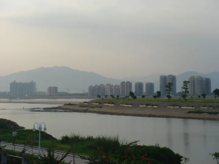 Riverside skyline with high-rise buildings under an evening sky in Qingxin District