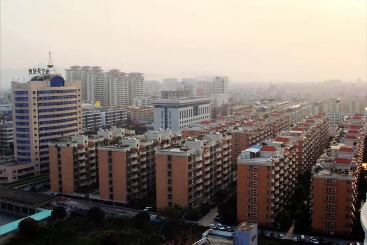 An elevated view of high-rise apartment blocks across urban Puning at dusk