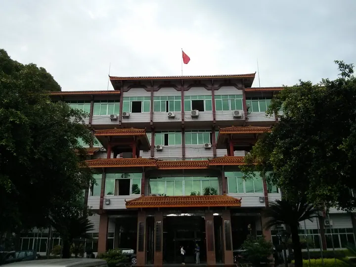 Multi-storey government building with traditional roof trim and a red flag