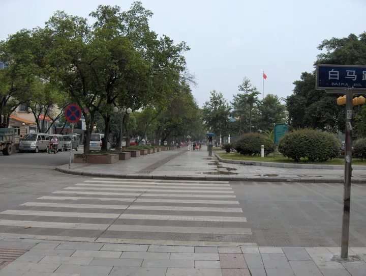 Street with a crosswalk and a road sign reading Baima Rd in Luocheng