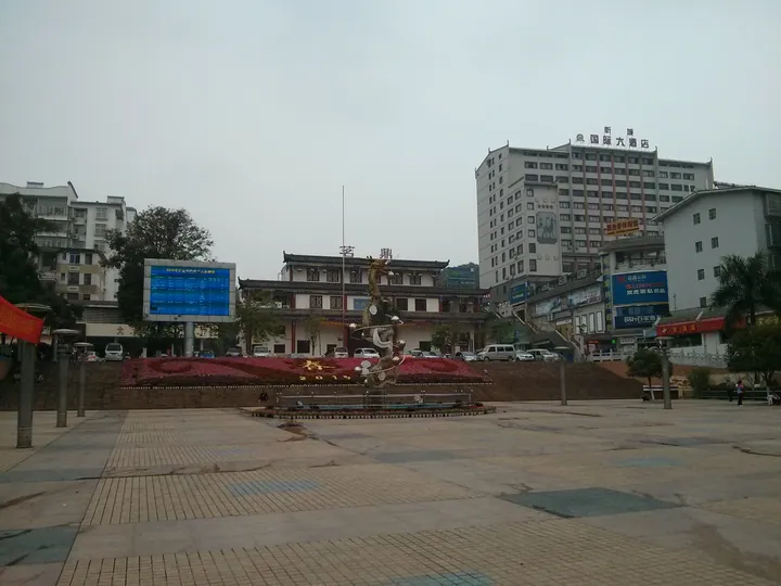 Town square with a sculpture and a high-rise hotel in Xincheng County