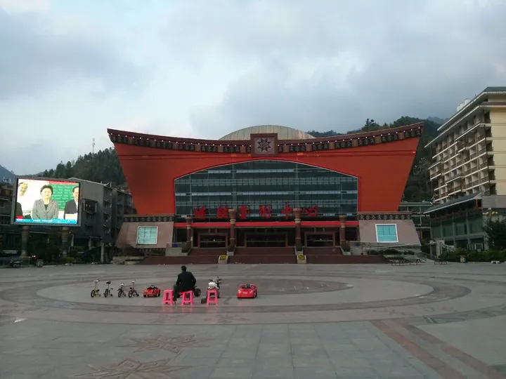 A large building with Yao ethnic architectural motifs facing a public square