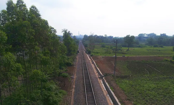 Railway line crossing green farmland near Ningming
