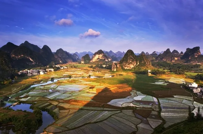 Karst hills overlooking a farming village at sunset in Tiandeng County
