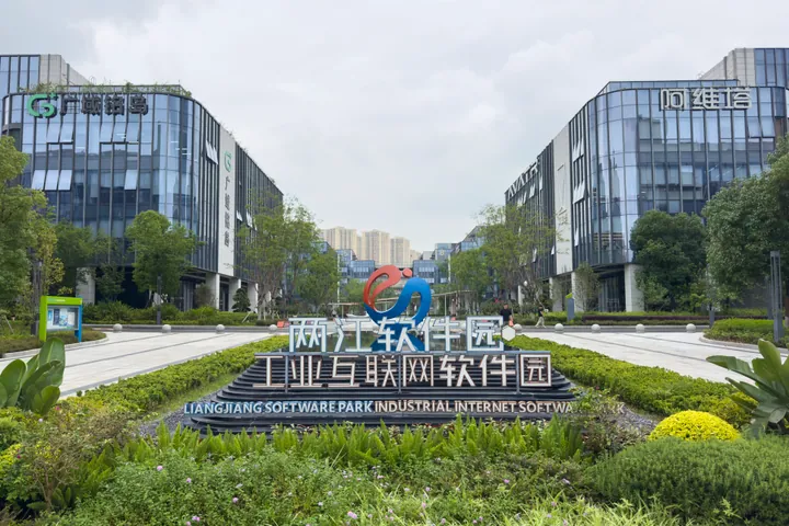 Modern glass office buildings flanking a landscaped plaza with a 'Liangjiang Software Park' sign in Chongqing