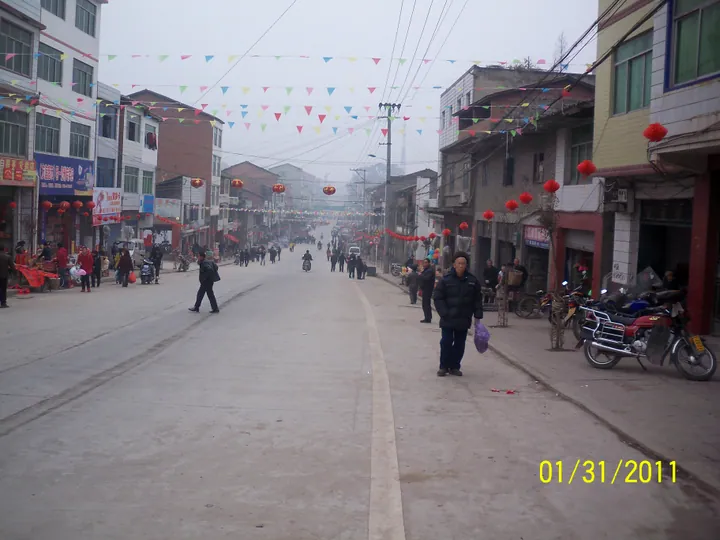 Small-town street with shops and pedestrians in Guang'an