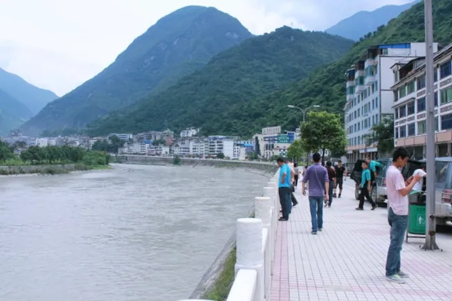 A riverside town with mountains behind it in Baoxing County
