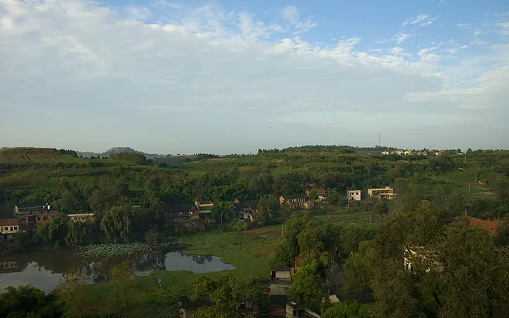 A pond and village houses among trees in Wuhuang Town, Yanjiang District