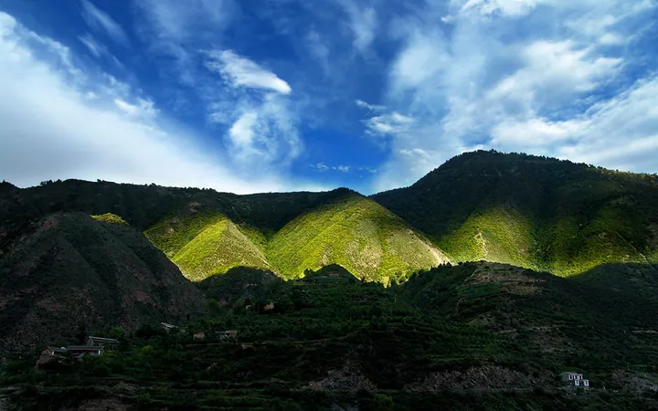 Sunlit green mountain ridges and terraced fields near Jinchuan County