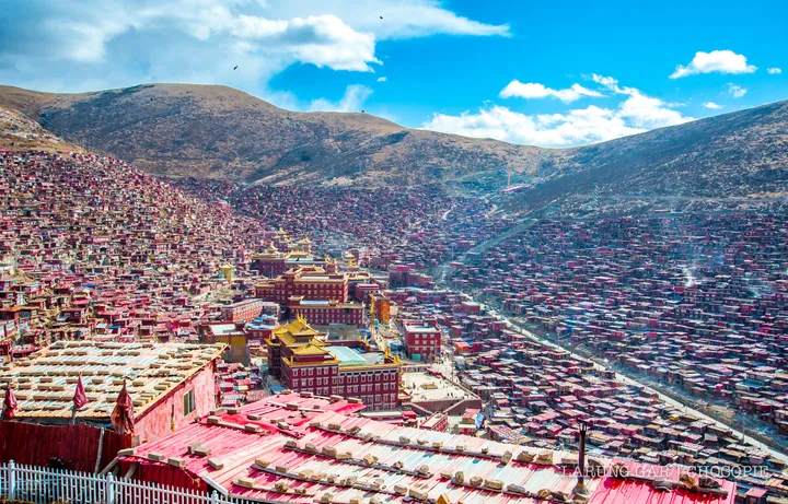 Thousands of small red monastic dwellings covering the hillsides of Larung Gar in Seda County