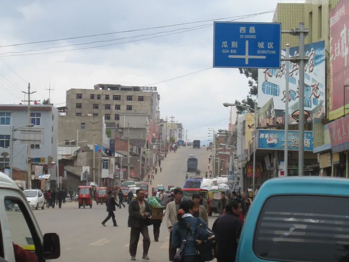 Busy street in central Yanyuan with a directional sign to downtown