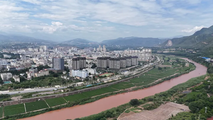 Aerial cityscape of Yuanjiang with the red-colored river running through it
