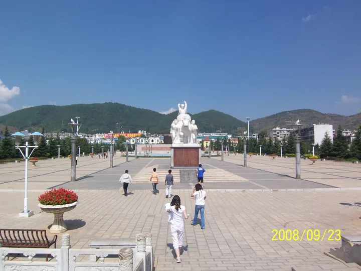 Town square with a stone monument, mountains in the background