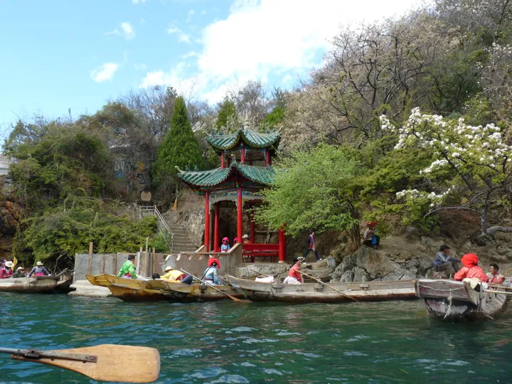 Traditional pavilion on a small lake island with boats, Ninglang County