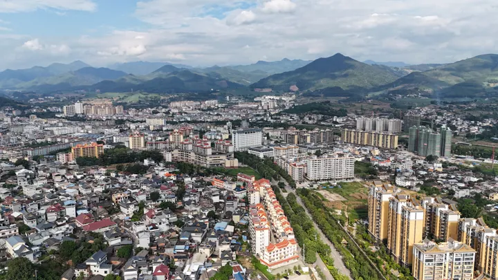 Aerial cityscape of Jinggu with mountains behind