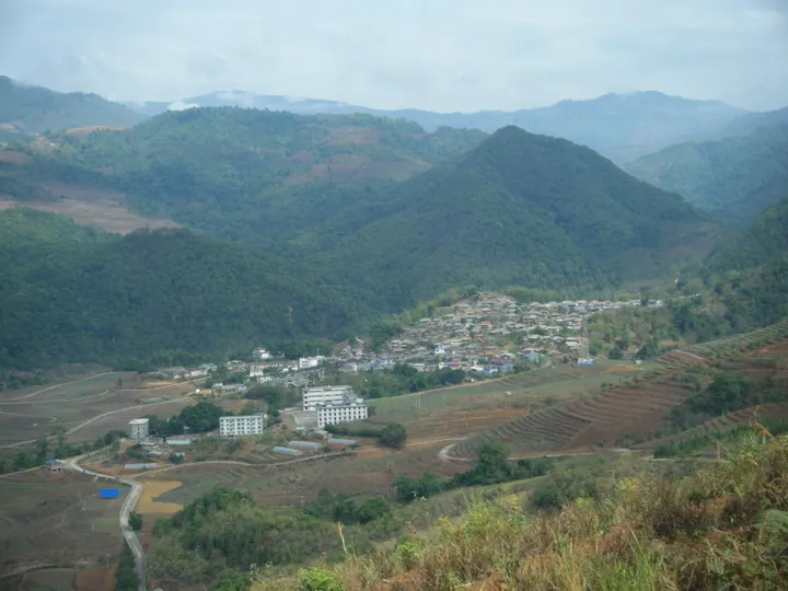Small mountain township surrounded by forested hills in Ximeng County