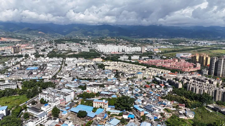 Aerial cityscape of Shuangjiang with mountains behind