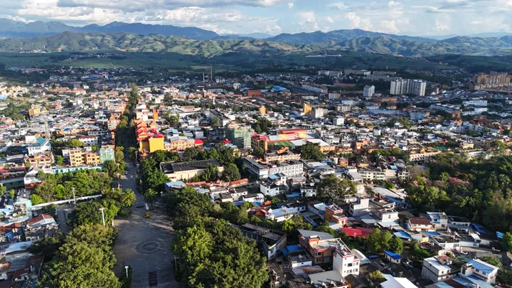 Aerial cityscape of Gengma in warm evening light with mountains behind