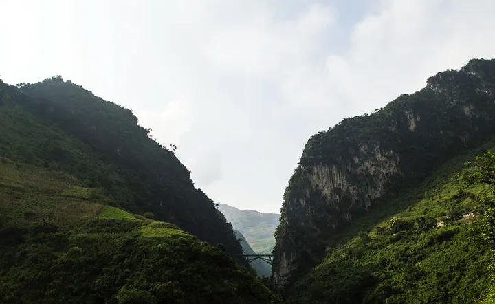 Steel railway bridge crossing a deep green canyon in Pingbian County