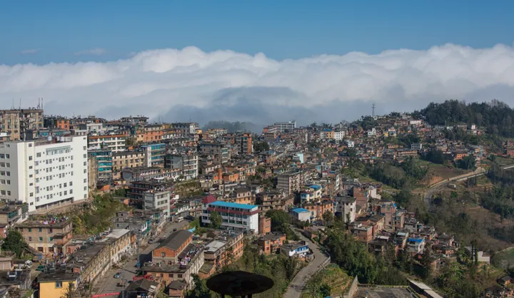 A hillside town partly covered by cloud in Yuanyang County