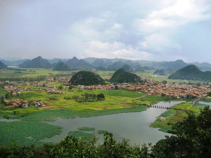 Karst peaks, a lake and a village at Puzhehei, Qiubei County