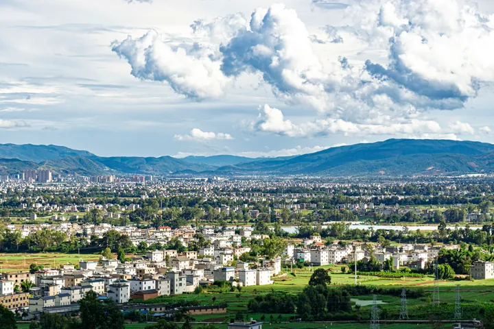 Skyline of the Midu county seat with hills in the background