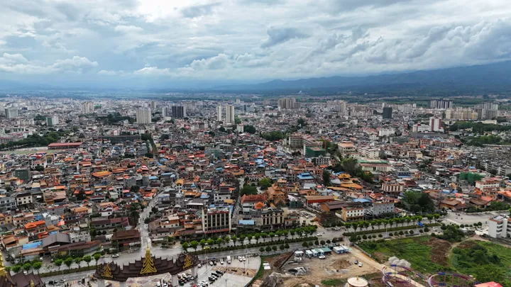 Aerial cityscape of Mangshi with distant mountains