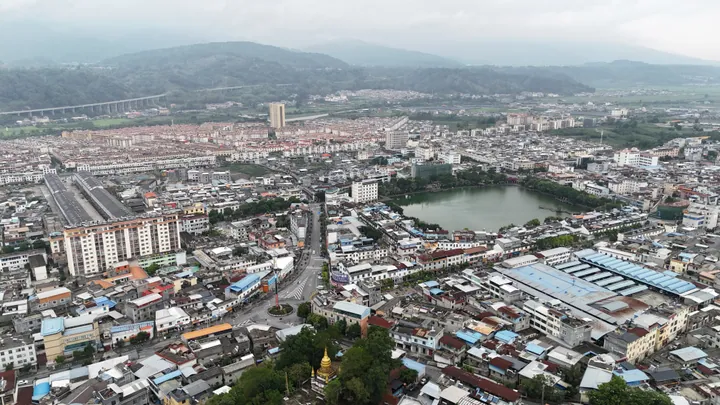 Aerial cityscape of Lianghe with a lake in the middle of town