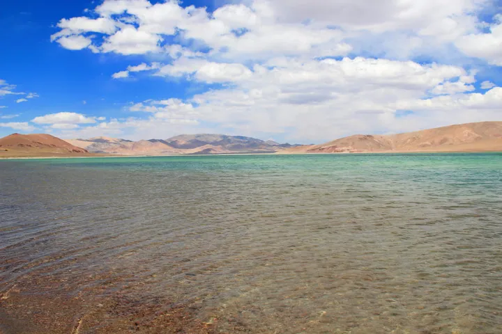 A lake surrounded by sand dunes and mountains, Nyer Tso in Gê'gyai County