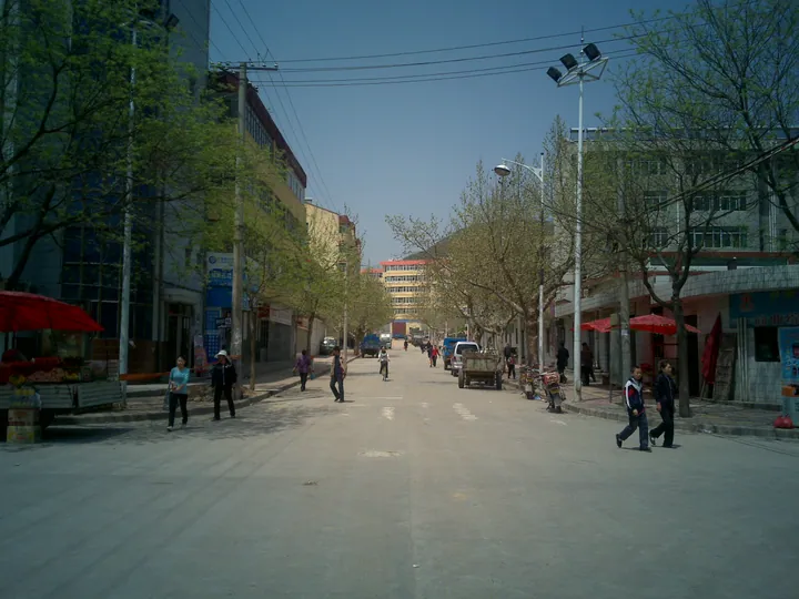 Small-town street with pedestrians and roadside shops