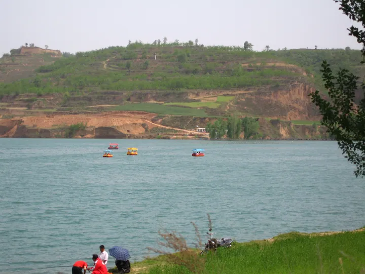 Lingao Lake with pedal boats and green hills in Baishui County