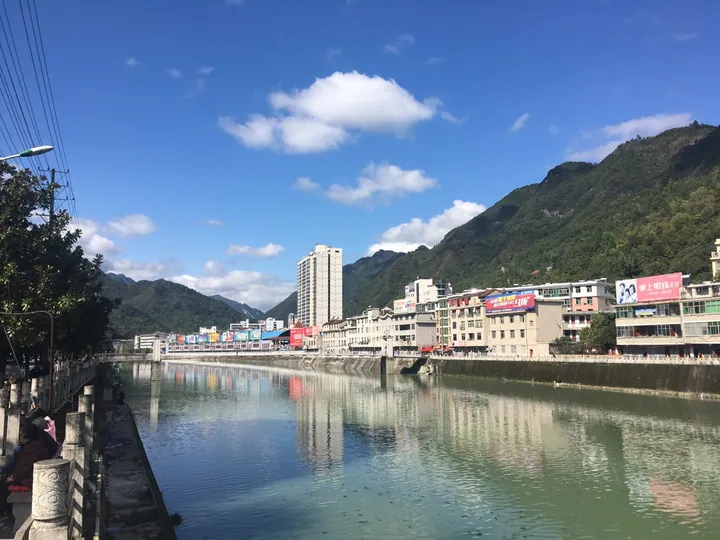 Zhenba county town along a river with mountains behind