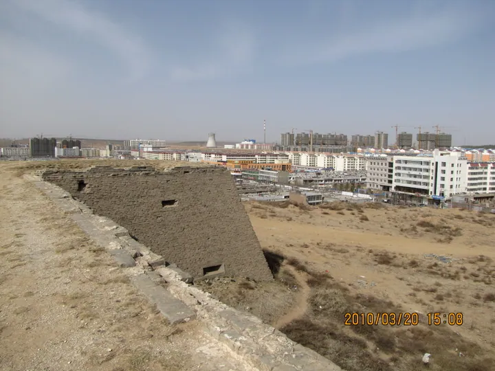 Historic wall ruins with the modern skyline of Hengshan District behind