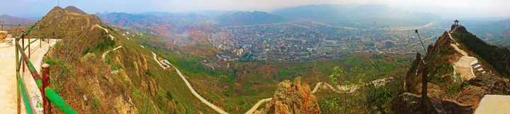 A hazy panoramic overview of Danfeng county town from a mountain viewing platform