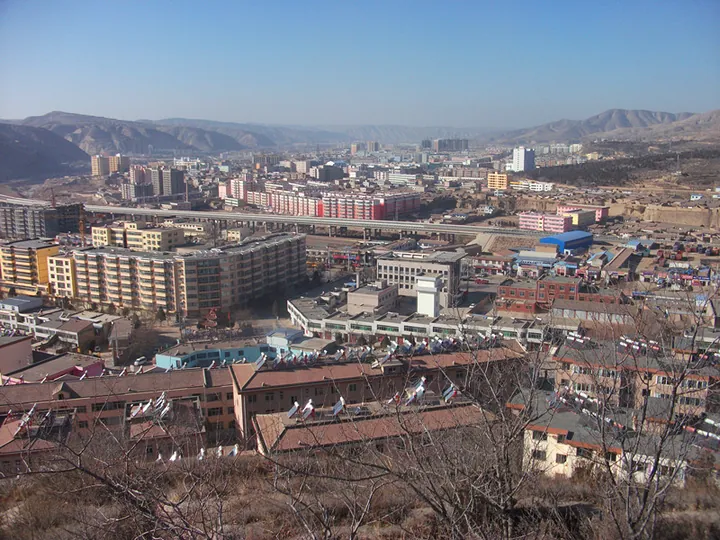 Wide view of Huining town with mountains and desert hills behind