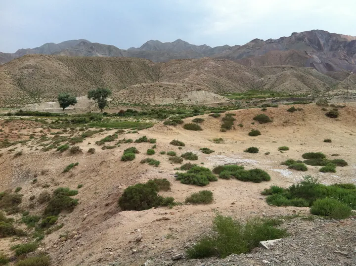 Scrubland and mountains under a partly cloudy sky near Jingtai