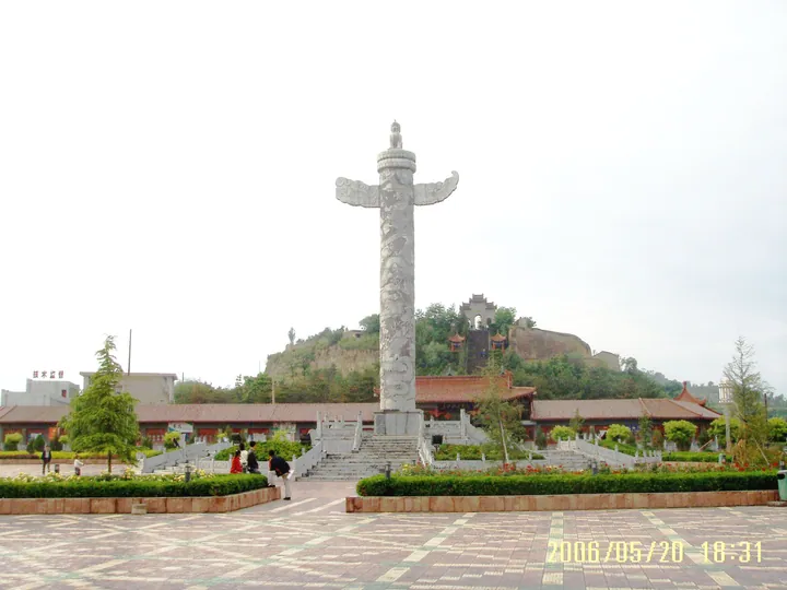 Carved stone pillar and pavilion on a hill above a public square in Ning County