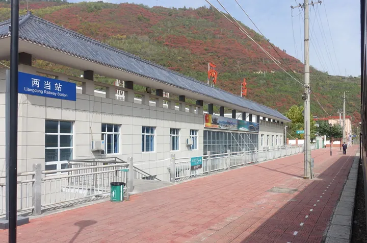 Station building signed 'Liangdang Railway Station' with autumn-coloured hillside behind