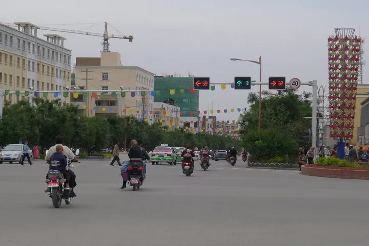 A city street with motorcycles and decorations in Kargilik County
