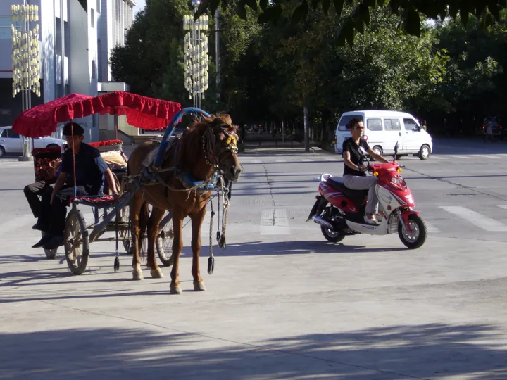 Street scene with a horse cart and a scooter in the Ili Kazakh Autonomous Prefecture