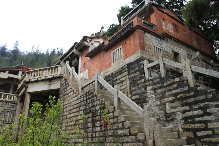 Exterior of the red-brick Cao'an temple building with a granite stairway