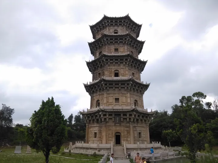 Full view of the stone Liusheng Pagoda with visitors at its base