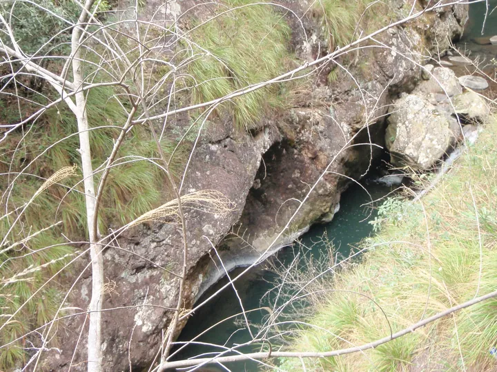 Mossy rock gorge with a small waterfall and stream flowing through