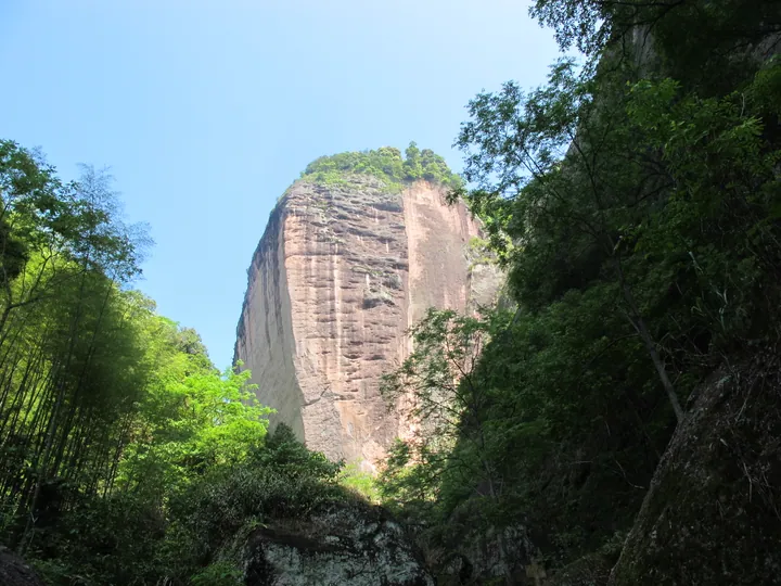 Tall sandstone cliff framed by trees at Zhaixia Grand Canyon, Taining County, Fujian