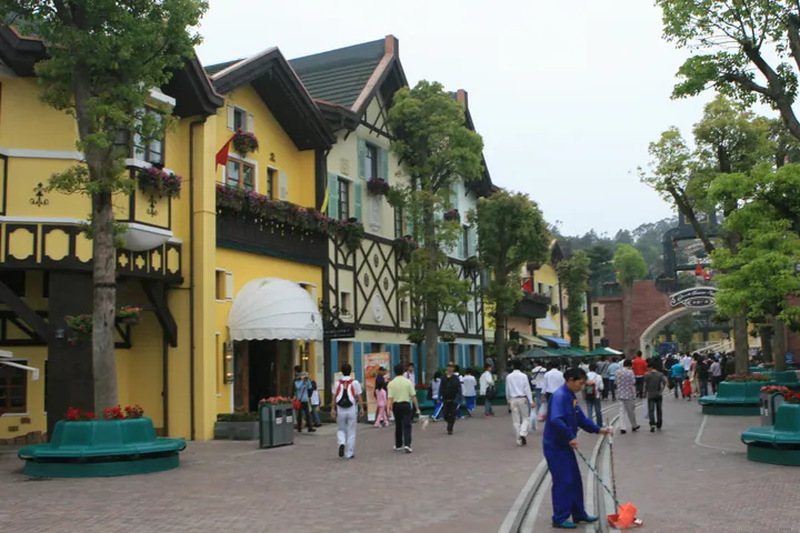 Colourful Bavarian-style buildings lining a pedestrian street with visitors walking by.
