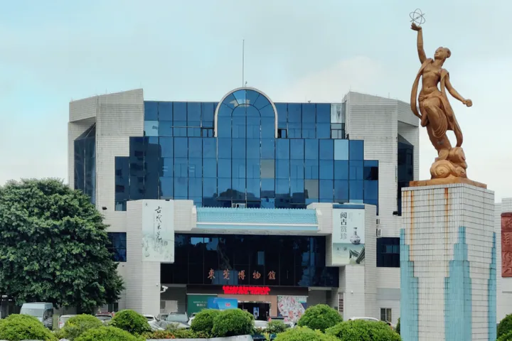 Modern building with 'Dongguan Museum' signage and a bronze statue in front