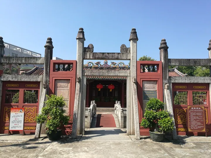 Two-storey red colonnaded building with an arched facade